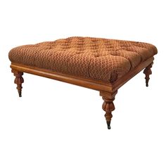 a footstool with wooden legs and an upholstered cushion on the top