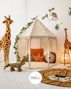 there is a stuffed giraffe and other animals in the room with it's tent