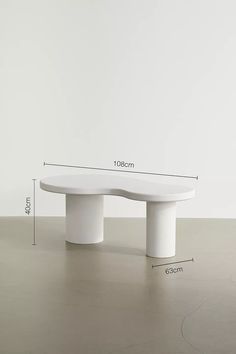 a white bench sitting on top of a wooden floor next to a wall with measurements