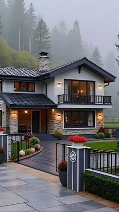 a large house in the middle of a foggy day with lots of trees and bushes