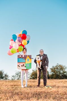 a man and woman standing in a field with balloons