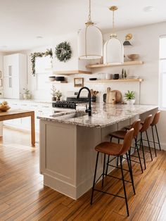 a kitchen with white cabinets and wooden floors