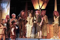 a group of people standing on top of a stage next to each other in costume