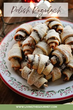 a white plate topped with pastries covered in powdered sugar next to a christmas tree