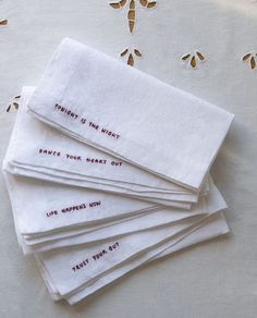 five embroidered napkins with words on them