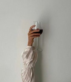 a woman holding a wine glass up to her face