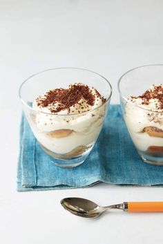 two desserts with whipped cream and chocolate sprinkles in small glass bowls