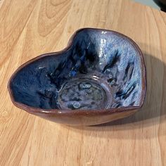 a heart shaped bowl sitting on top of a wooden table