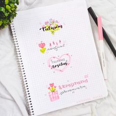 a notebook with some writing on it next to a pen and flower pot filled with flowers