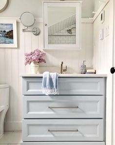 a bathroom with white walls and drawers