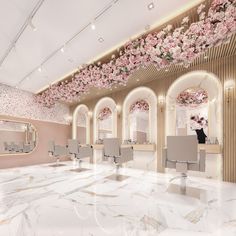 the interior of a hair salon with white chairs and pink flowers on the ceiling above them