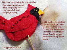 a close up of a red bird on a stick with words written in the background