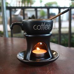 a coffee pot with a candle in it on a table