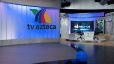 a television studio with two monitors and a tv screen on the wall that says twazeta