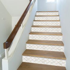 a set of stairs leading up to the second floor with decorative wallpaper and wood handrails