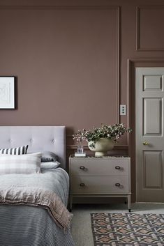 a bedroom with pink walls and white furniture