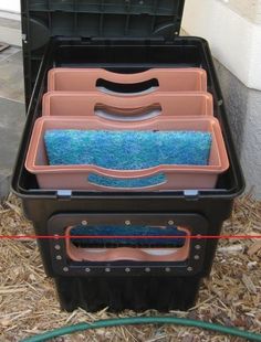 an open tool box filled with tools on top of dry grass next to a building