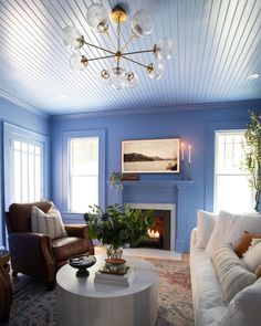 a living room filled with furniture and a fire place in the middle of the room