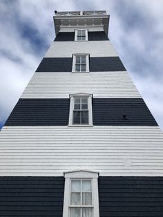 a tall black and white building sitting under a cloudy sky