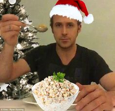 a man in a santa hat is eating popcorn from a bowl with a fork and spoon