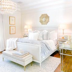 a bedroom with white furniture and chandelier