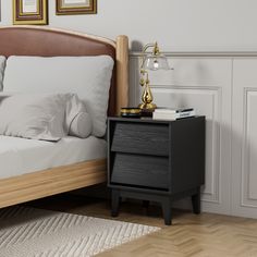 a bed sitting next to a night stand on top of a wooden floor