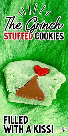 a piece of cake that is on top of some green furry material with the words, the grin stuffed cookies filled with a kiss