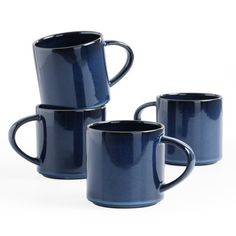 three blue mugs sitting next to each other on a white surface with no one around them