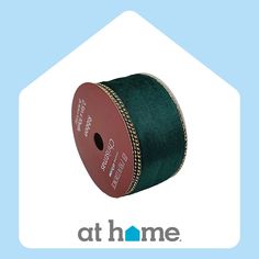 a spool of green satin ribbon on a blue background with the words at home