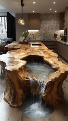 a large wooden table with water running down it's center island in the middle of a kitchen