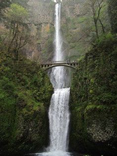 a large waterfall with a bridge over it