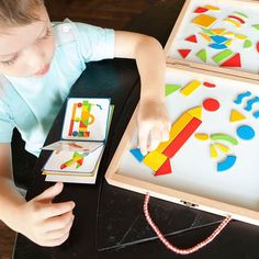 a young boy is playing with magnets on a table