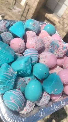 there are many different types of candy in the tray on the table, including blue and pink