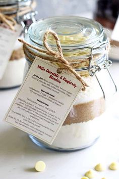 two jars filled with different types of food and some tags on the top one is labeled hello chocolate & raspberry