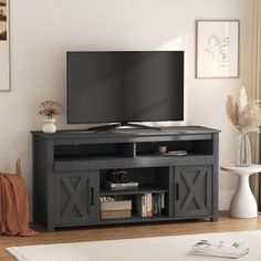 a flat screen tv sitting on top of a wooden entertainment center in a living room