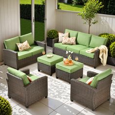 an outdoor patio with green cushions and furniture