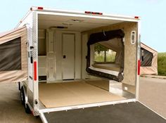 an enclosed camper trailer with the door open