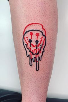 a person with a tattoo on their leg that has a red and black design on it