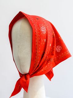 a white mannequin wearing a red head scarf