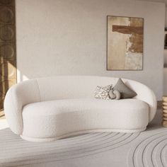 a white couch sitting on top of a bed in a living room next to a painting