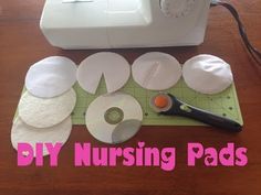 the sewing machine is next to several nursing pads and a pair of scissors on a cutting board