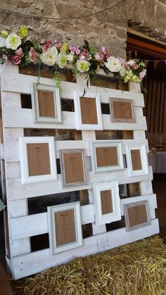 an old pallet is decorated with flowers and frames for seating on hay bales