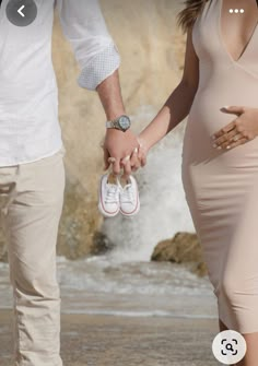 a pregnant woman holding the hand of a man