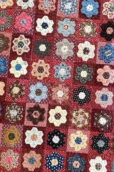 a red quilt with many different designs on it