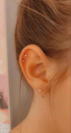 a close up of a person's ear with two piercings