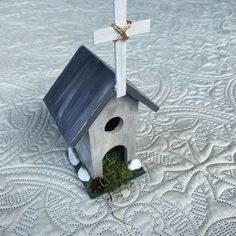 a small birdhouse with a cross on top