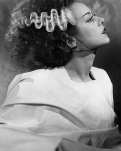 a black and white photo of a woman with curls in her hair looking off to the side