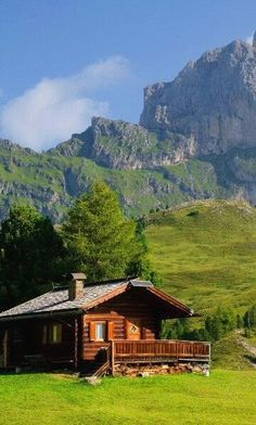 black and white photograph of a cabin in front of a mountain range with a large rock outcropping