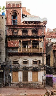 an old run down building with lots of windows and balconies on the side