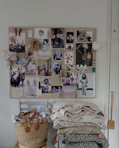 a pile of clothes sitting on top of a floor next to a wall covered in pictures